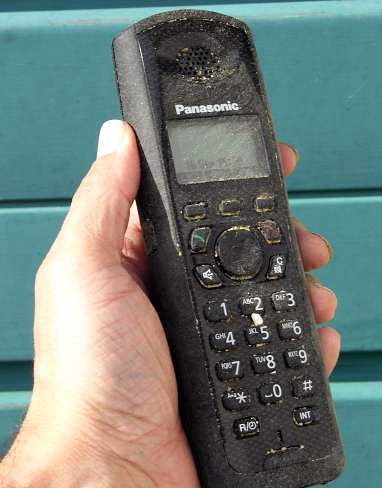 Hand holding a well-used Panasonic KX-TG6481ET DECT phone.