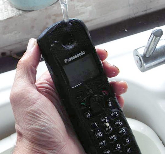 Panasonic rugged phone held under running water.