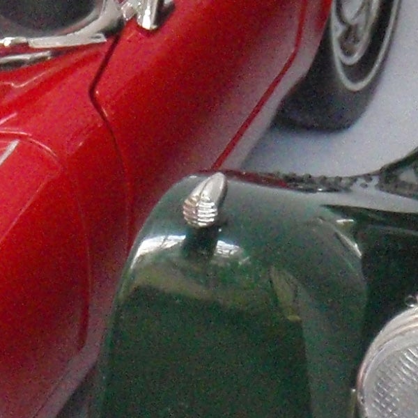 Close-up of red and green vintage cars.