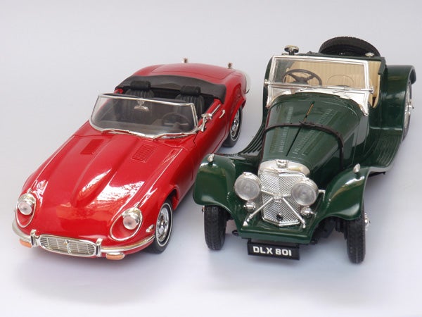 Red and green vintage toy cars on white background.