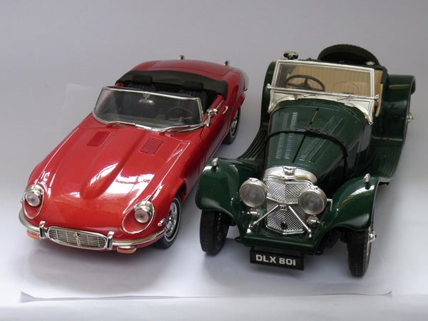 Red and green vintage model cars on white background.
