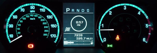 Jaguar XF dashboard at night showing speedometer and odometer.