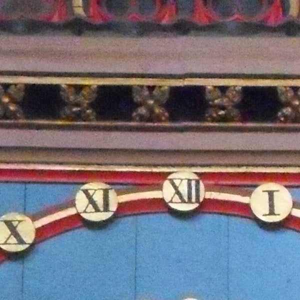 Close-up of colorful painted Roman numerals on a wall.