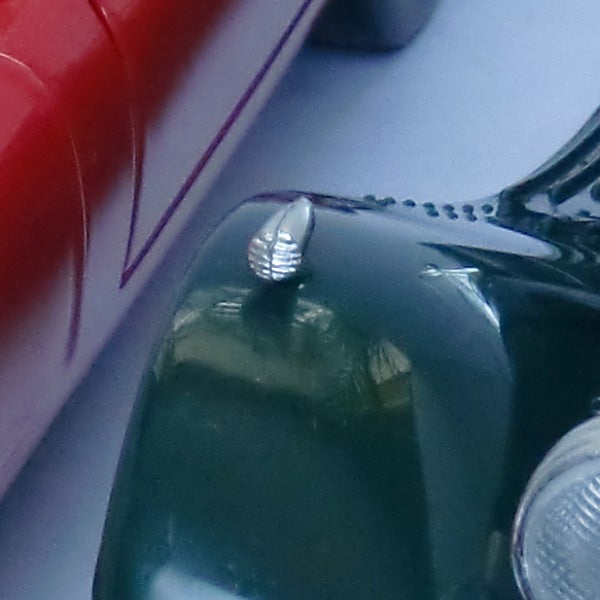 Close-up of a screw on a green surface with background.