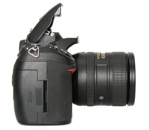 Nikon D300s DSLR camera with lens and open flash.
