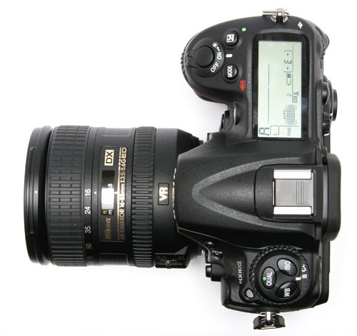 Nikon D300s DSLR camera with lens on white background.