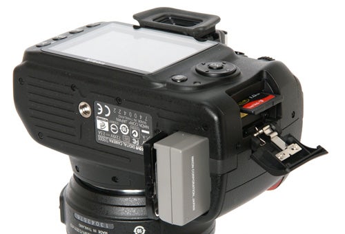 Nikon D3000 DSLR with open memory card slot.