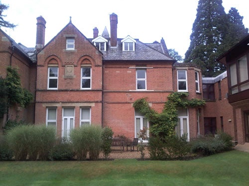 Brick building with manicured lawn and trees.