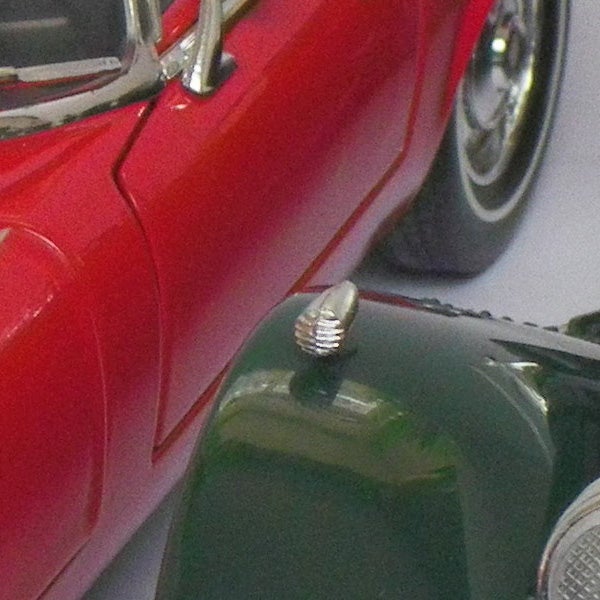 Close-up of a red toy car reflected in camera lens