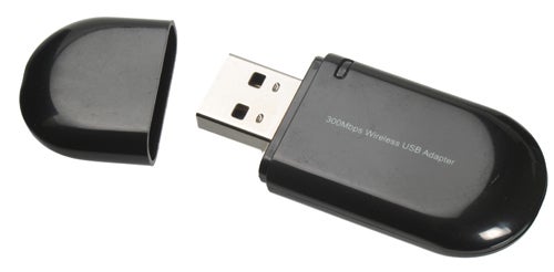 Wireless USB adapter with detached cap on white background.