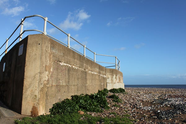 Concrete sea defense structure against a clear blue sky