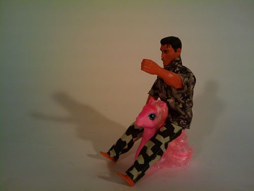 Action figure riding a toy horse on a white background.
