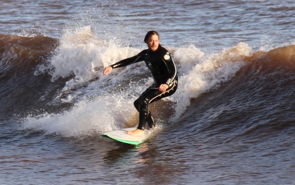 Surfer riding a wave, captured with Canon EOS 7D.