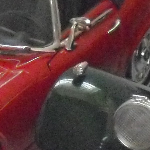 Close-up of a red vintage car with chrome details.