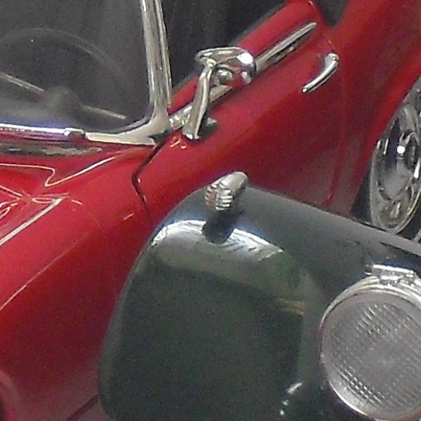Close-up of a red vintage car model.