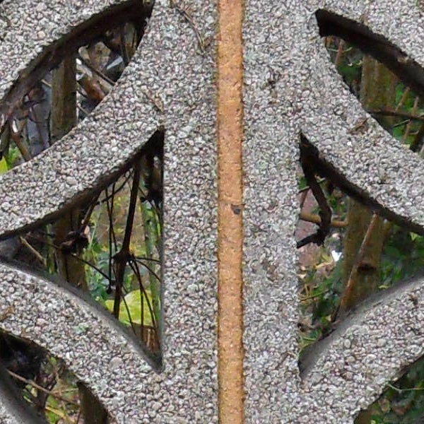 Close-up of a rusty metal wheel with intricate patterns.