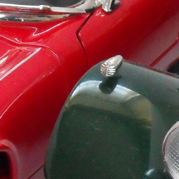 Close-up of a red vintage car model side mirror.