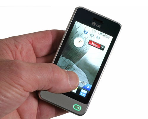 Hand holding an LG GD510 Pop phone displaying home screen.