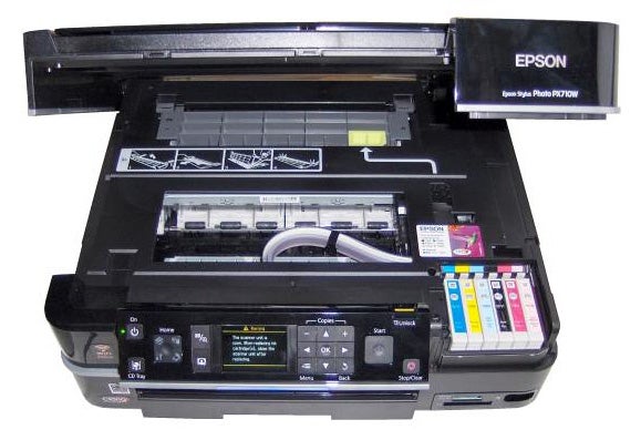 Epson Stylus Photo PX710W printer with open panels and ink cartridges visible.