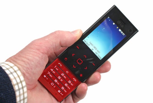 Hand holding an LG Chocolate BL20 slider phone.