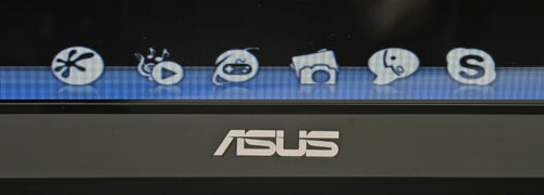 Close-up of Asus laptop screen with icon stickers and logo.