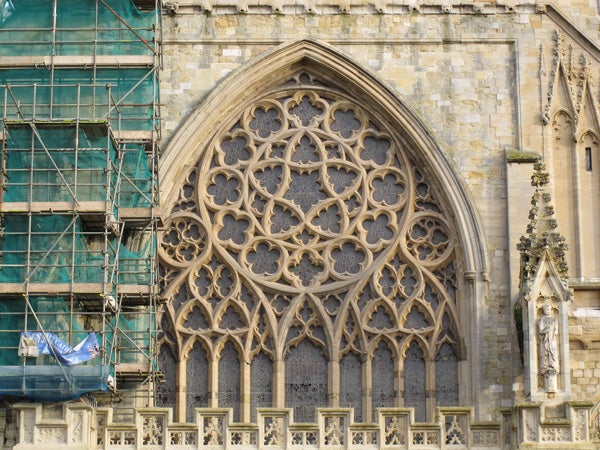 Detailed photo of gothic architecture with scaffolding on the left.