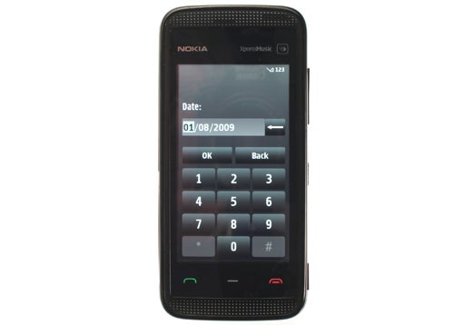 Nokia 5530 XpressMusic phone with date display on screen.
