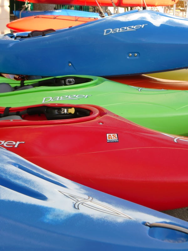 Colorful kayaks stacked together outdoors.