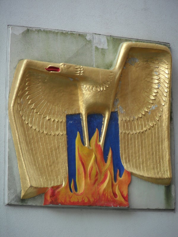 Golden eagle sculpture with outstretched wings and stylized flames
