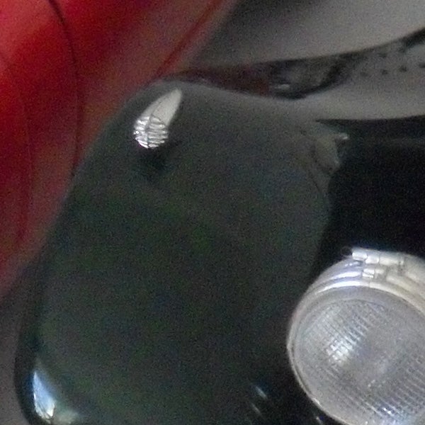Close-up of a object with metallic and red parts.