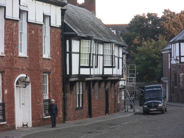Old half-timbered building with a person and a delivery van.