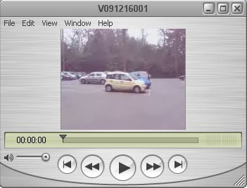 Video player interface with a paused video showing cars in a parking lot.