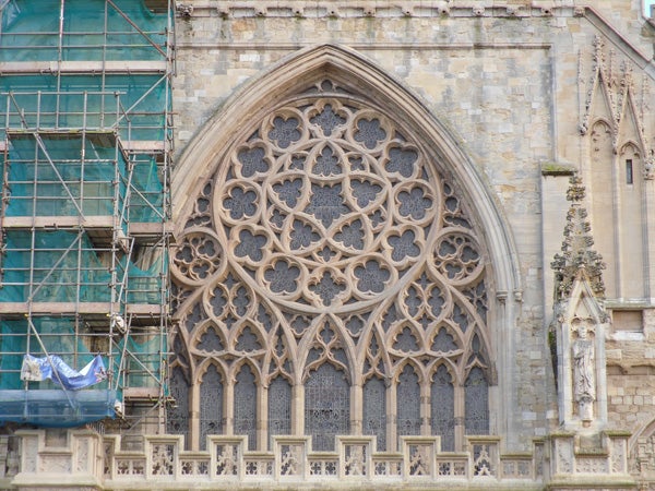 Ornate gothic church window with scaffolding on the side