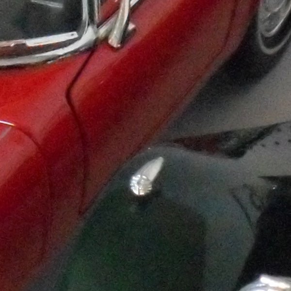 photo of a red car's side and mirror.