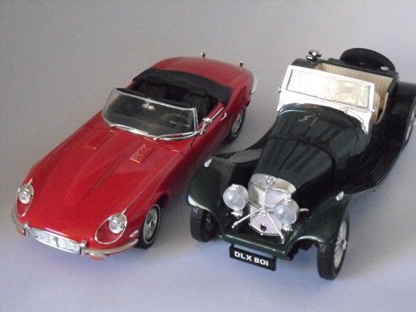 Two model cars, a red Jaguar E-Type and black vintage car.