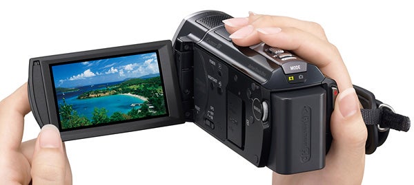 Hands holding a Sony HDR-CX505VE camcorder with a scenic display.