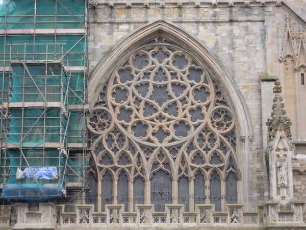 Gothic window architecture with intricate stonework and scaffolding.