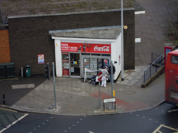 Street view of a small convenience store and pavement from above.