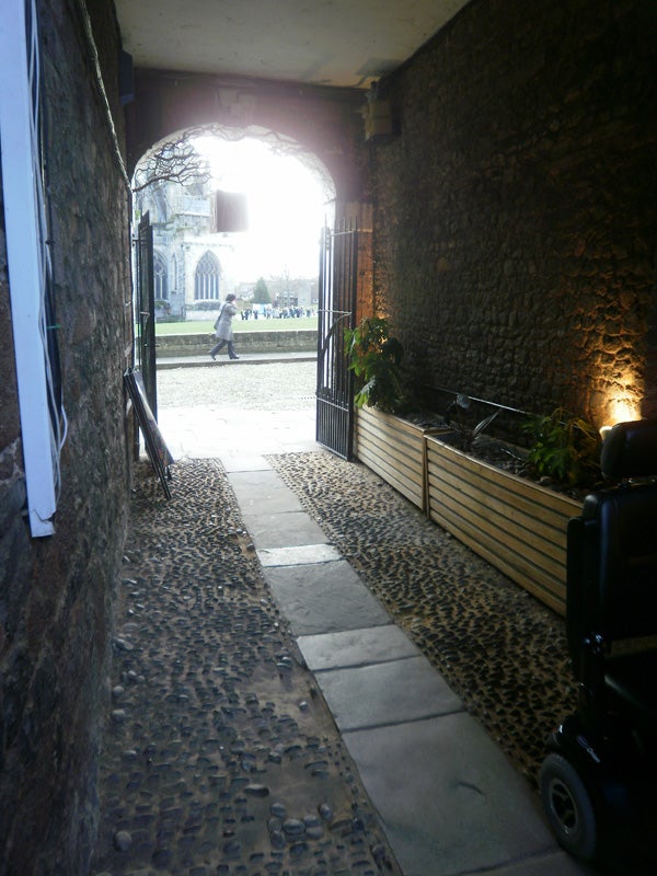 Stone alleyway with a view leading to an outdoor area.