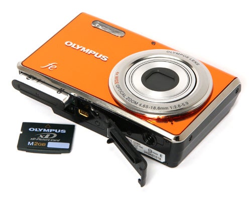 Olympus FE-4000 camera with open battery compartment and memory card.