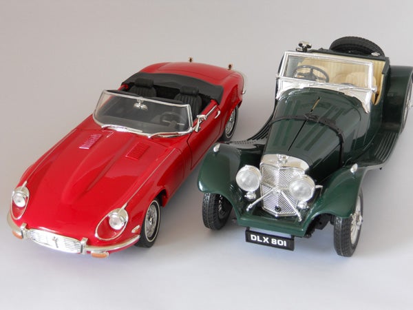 Red and green model cars on a gray background.