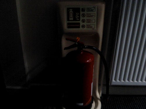 Fire extinguisher next to safety instructions on wall