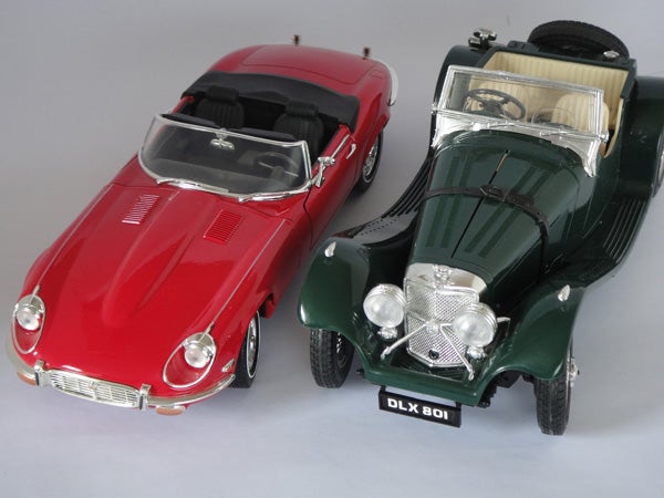 Red and green vintage model cars on display