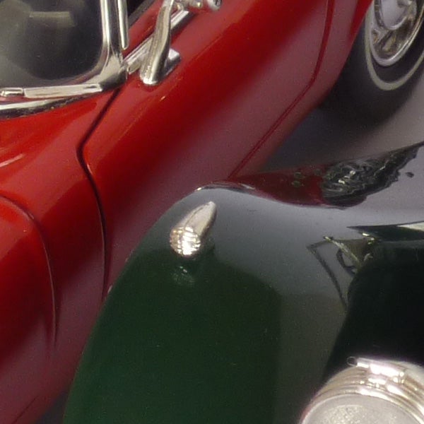 Close-up image of a red toy car with reflective surface.
