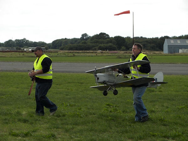 Two men carrying a model airplane on a field.Two men carrying a model airplane across a grass field.Screenshot of Corel PaintShop Photo Pro X3 Smart Carver feature.