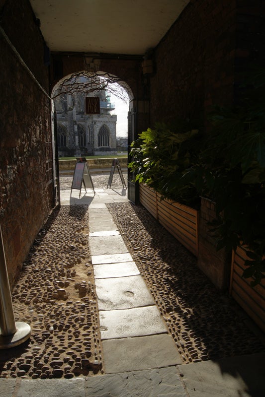 Photograph taken with Sony Alpha A500 showing a narrow alley and cathedral.