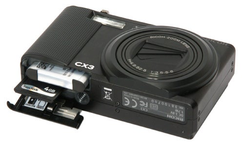 Ricoh CX3 camera with SD card slot open.