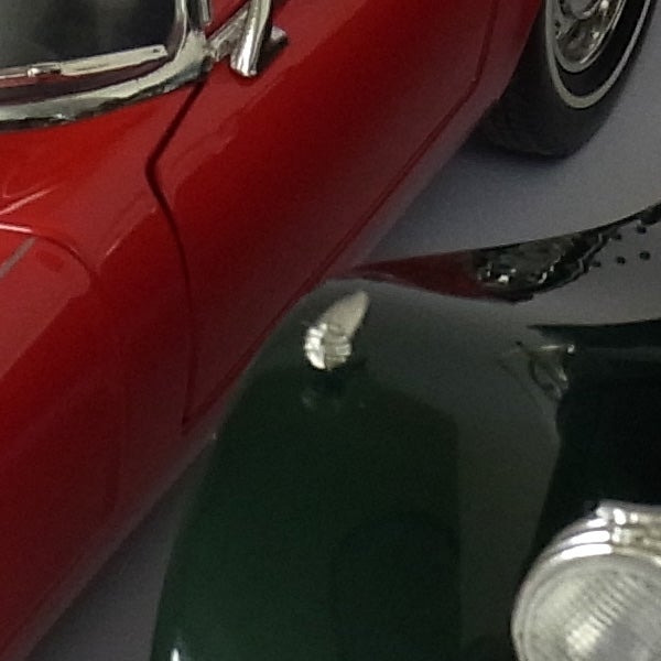 Close-up of vintage cars reflecting on shiny surface.
