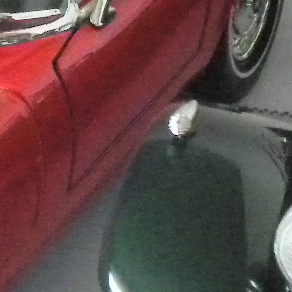image of a red car and black object.