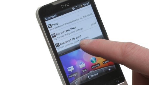 Hand interacting with the HTC Legend smartphone touchscreen.